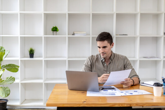 Business owner preparing financial statements for loan applications at desk