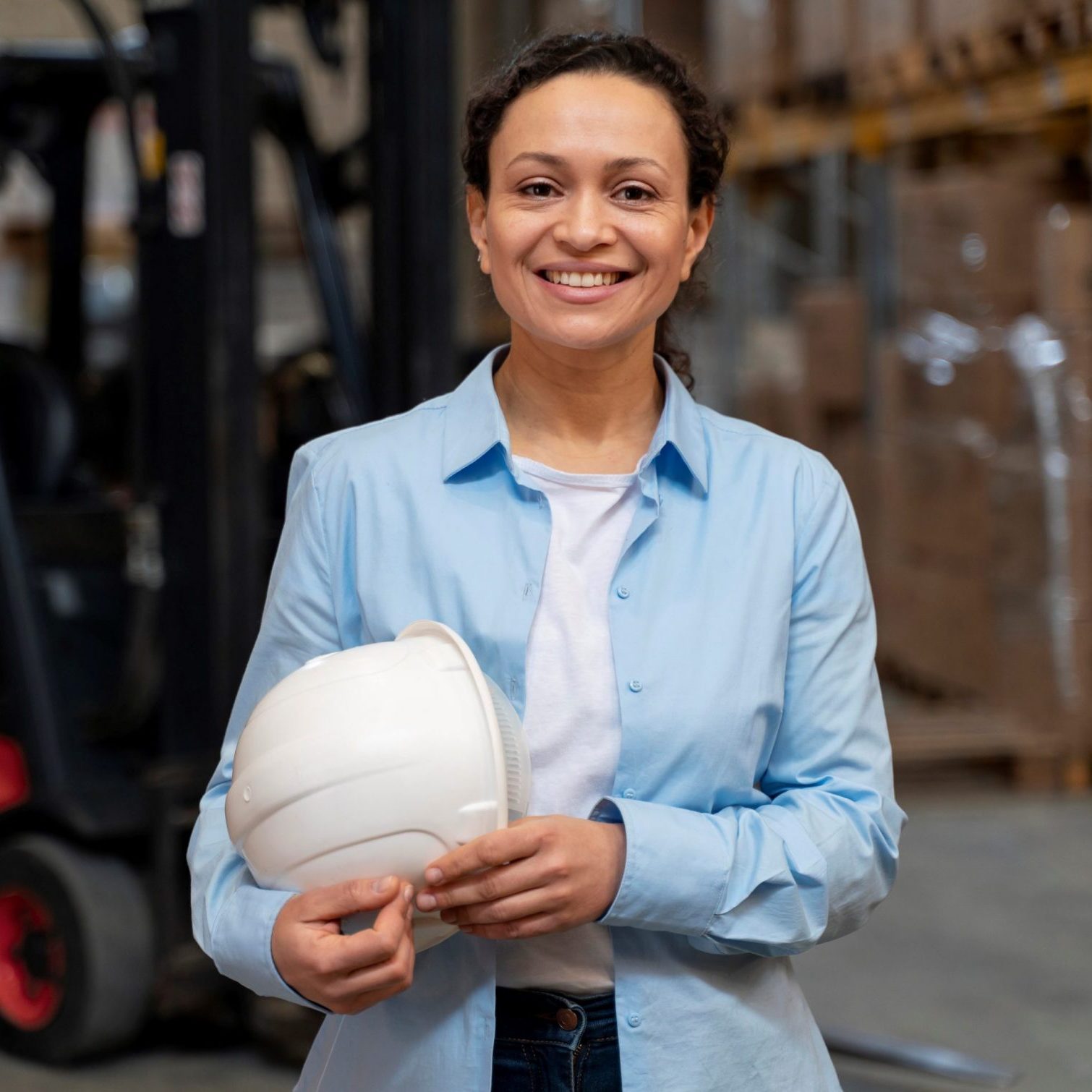 Woman holding safety helmet illustrates blog "4 Benefits of Investing in New Equipment for Your Business"