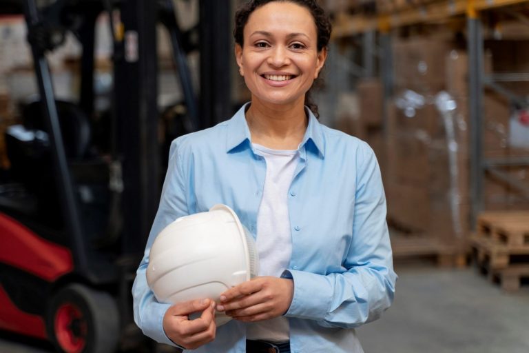 Woman holding safety helmet illustrates blog "4 Benefits of Investing in New Equipment for Your Business"