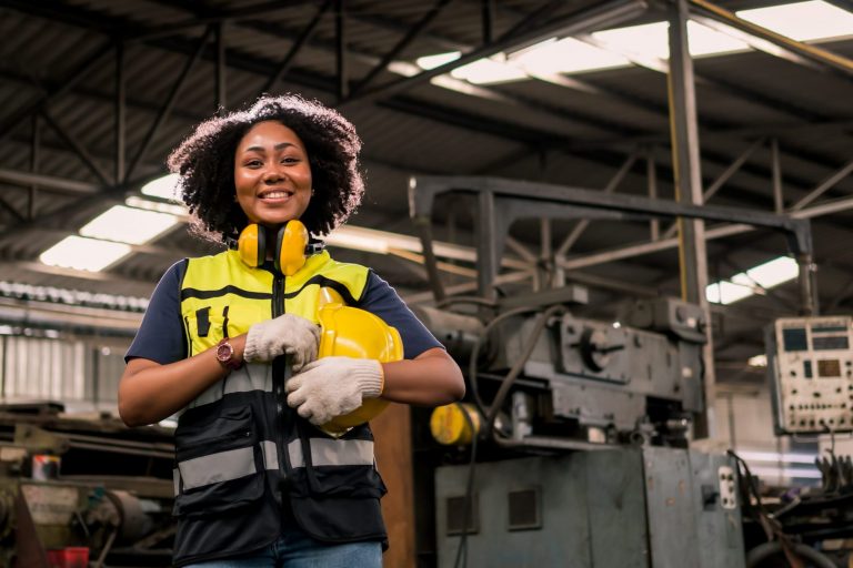 Photo of smiling woman holding safety helmet illustrates blog "Equipment Financing: Definition and Examples"