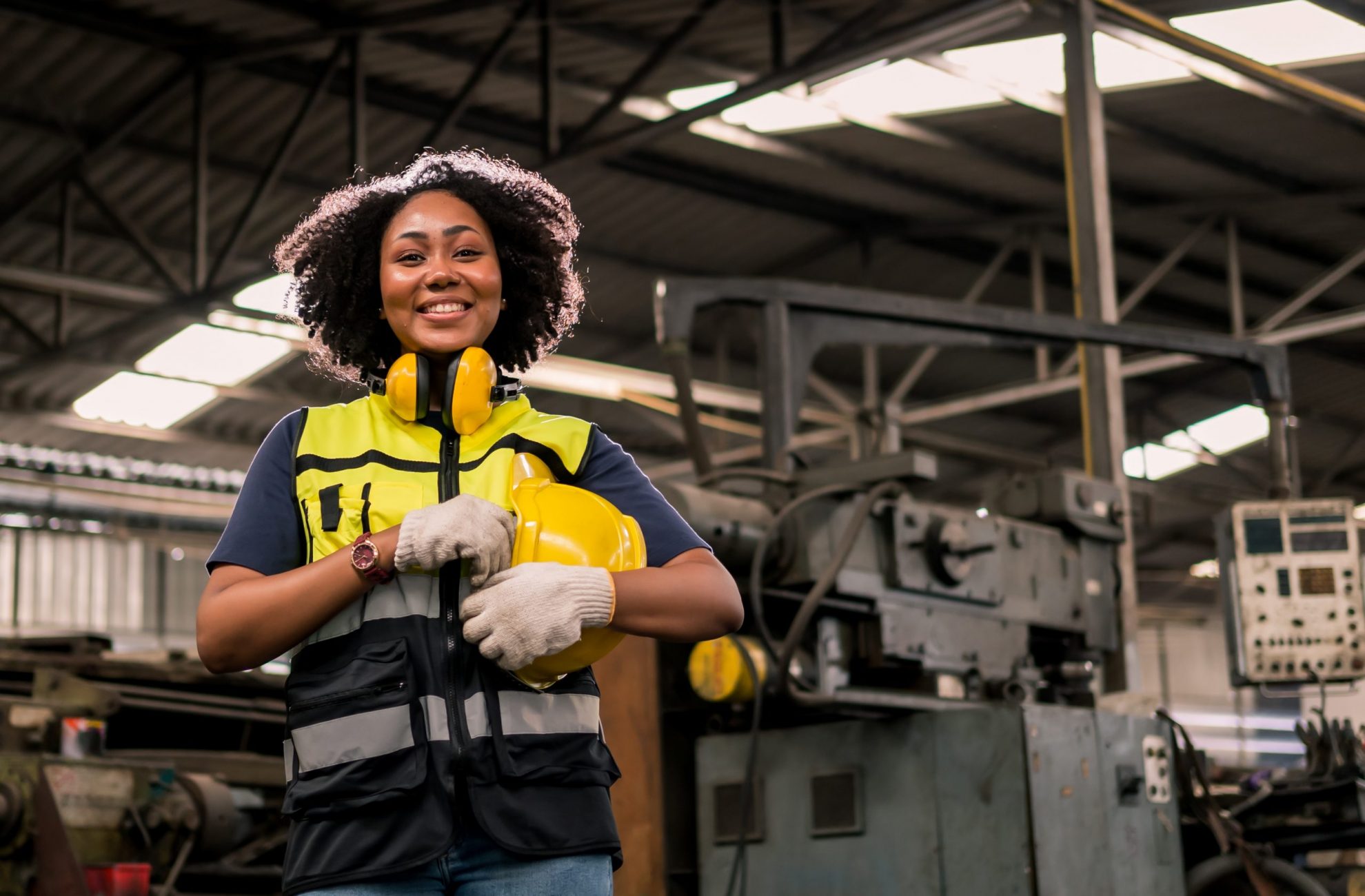 Photo of smiling woman holding safety helmet illustrates blog "Equipment Financing: Definition and Examples"