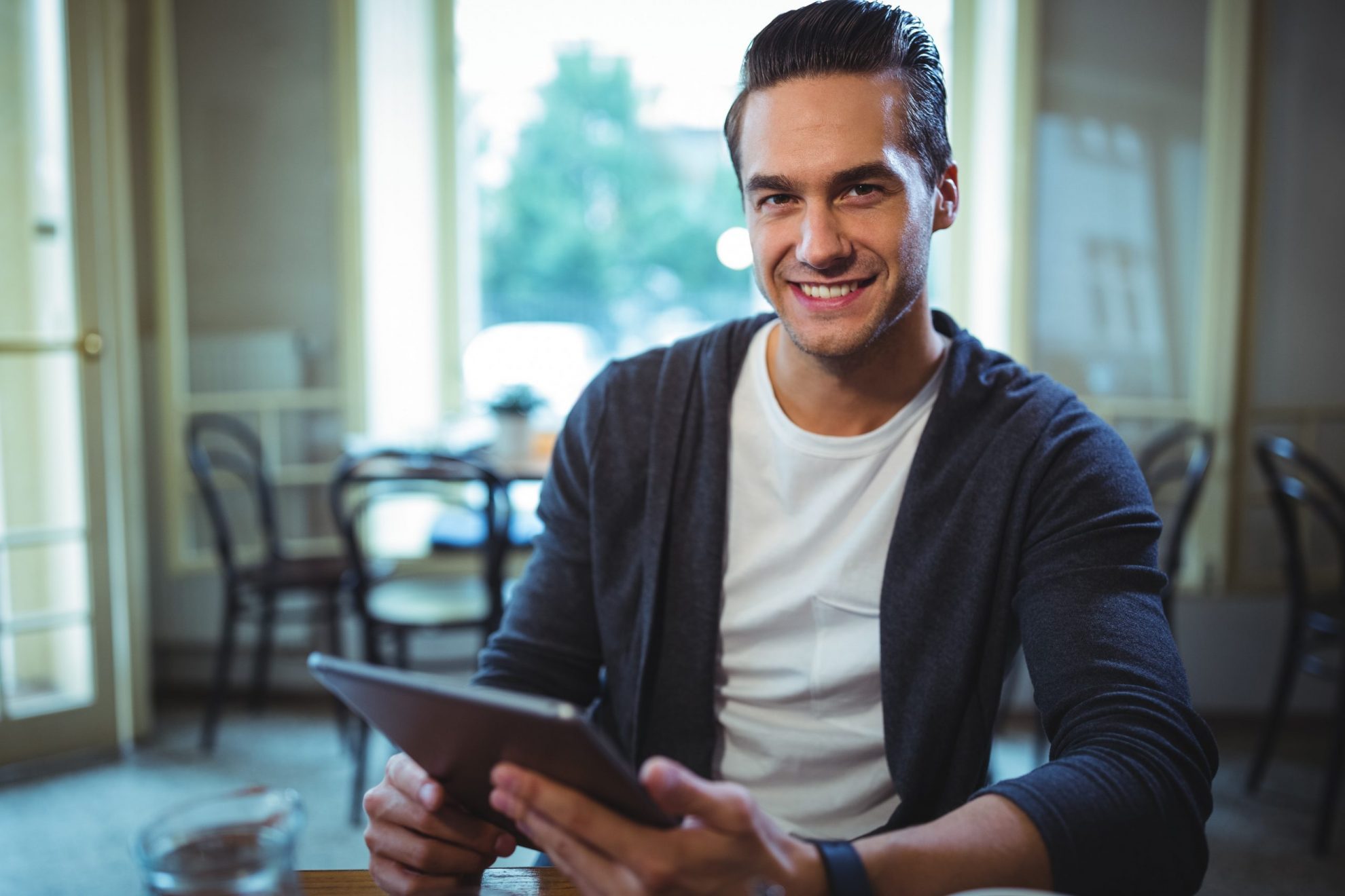 Young man holding tablet illustrates blog "5 Tips for Starting a New Business"