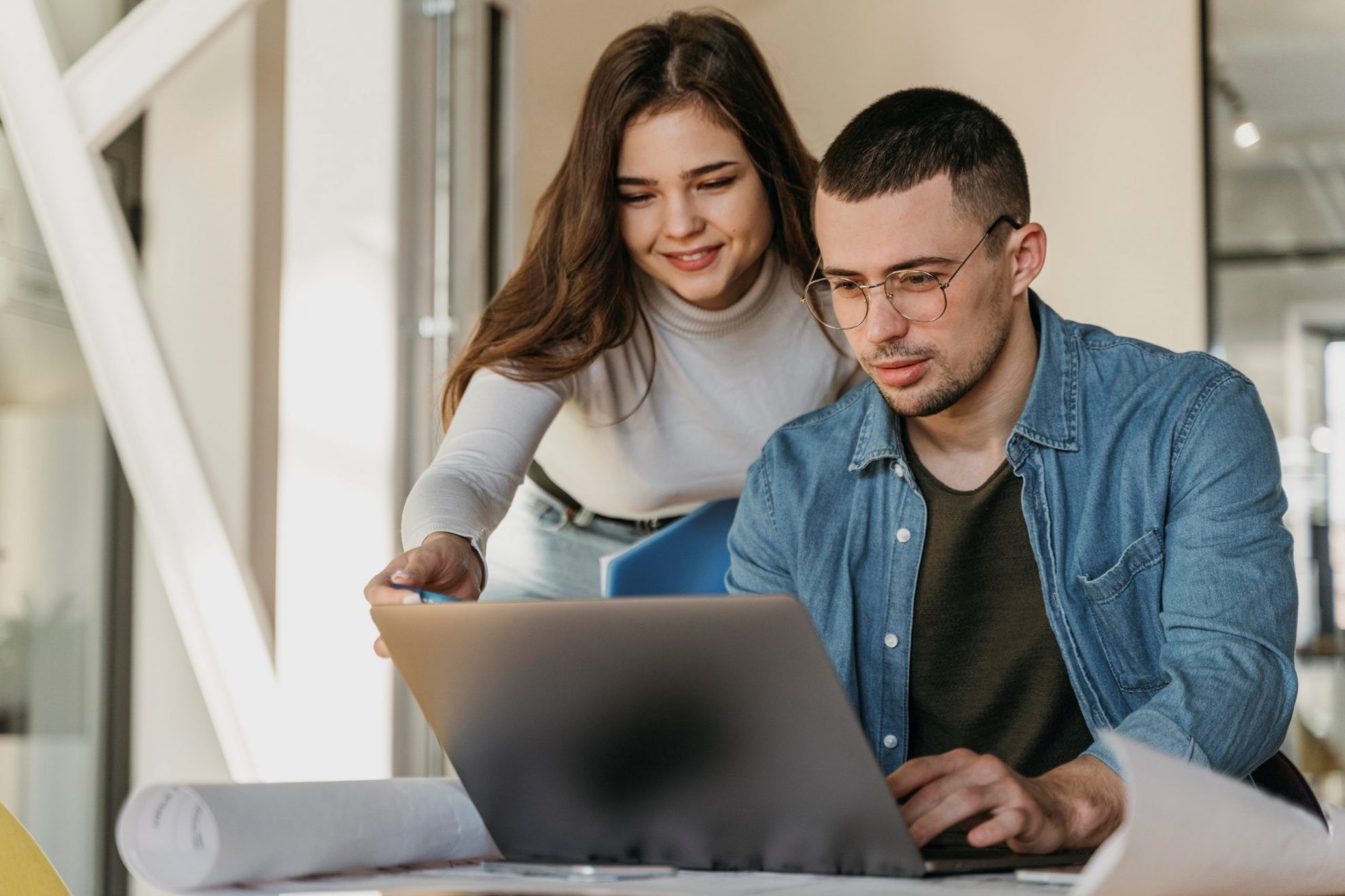 Photo of man and woman in front of laptop illustrates blog: "Is It a Good Idea to Take Out a Business Loan to Manage the Effects of Inflation?"