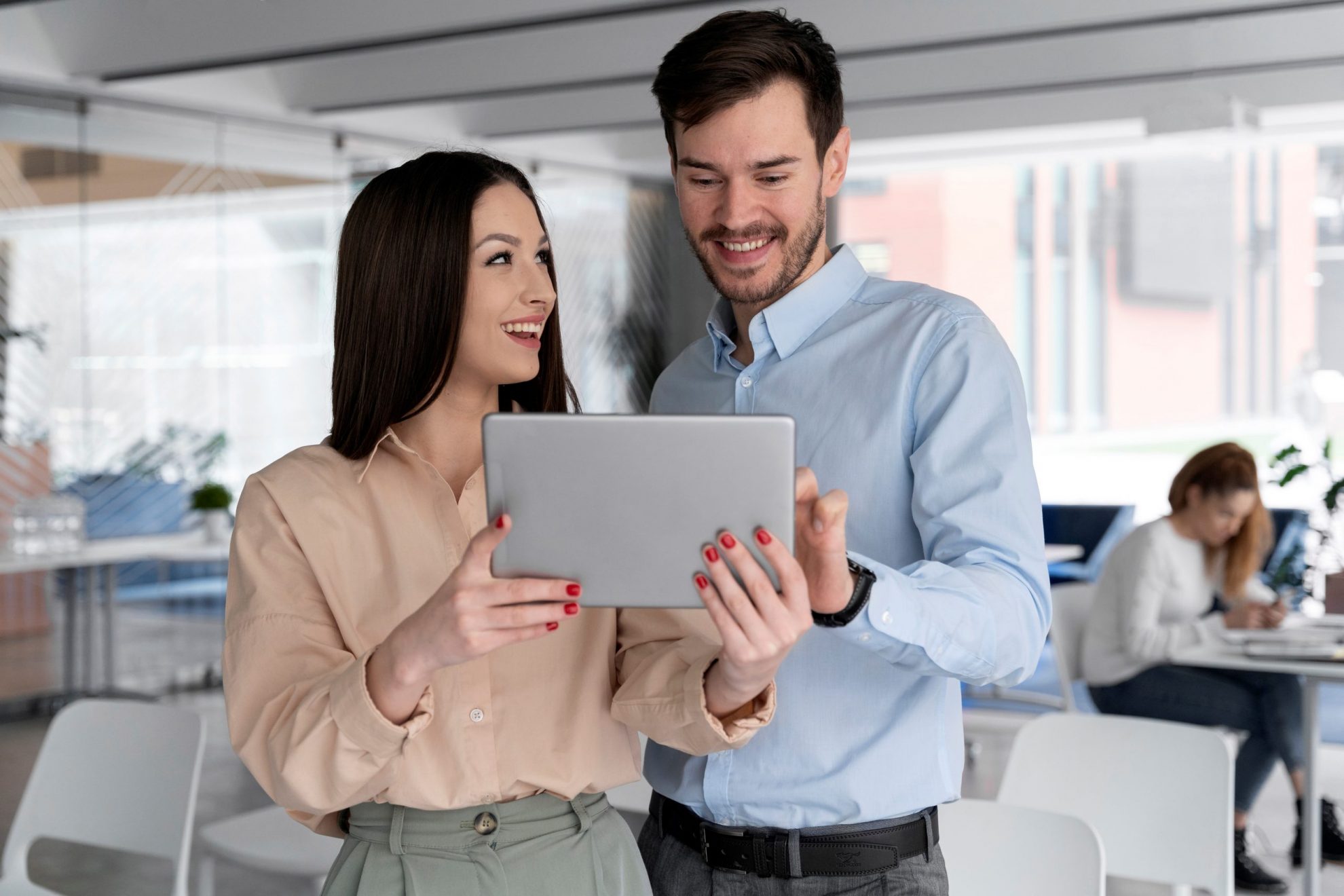 Woman and man looking at tablet illustrate blog "5 Ideas To Improve Your Company’s Cash Flow"