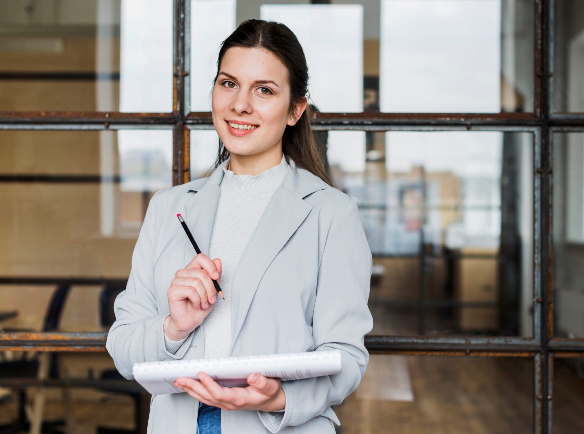 Woman holding pencil illustrates blog "Are Business Loans Secured or Unsecured?"