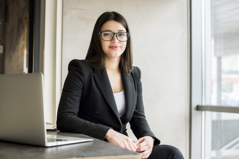 Female executive sitting at desk with laptop illustrates blog "Understanding SBA Loans"