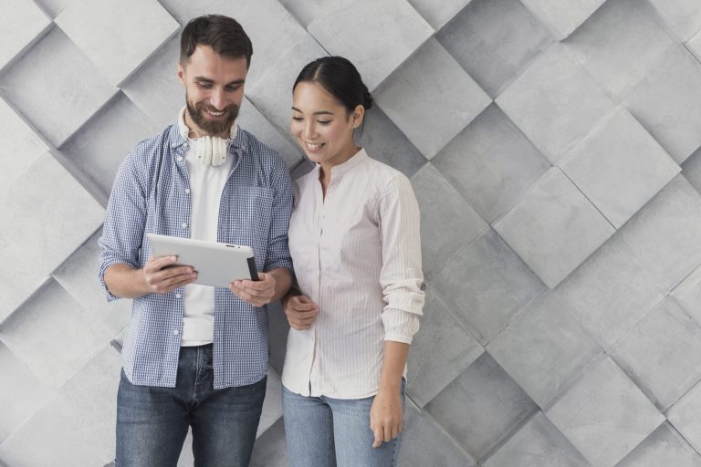 Mand and woman looking at tablet illustrate blog "Are Business Loans Fixed or Variable?"