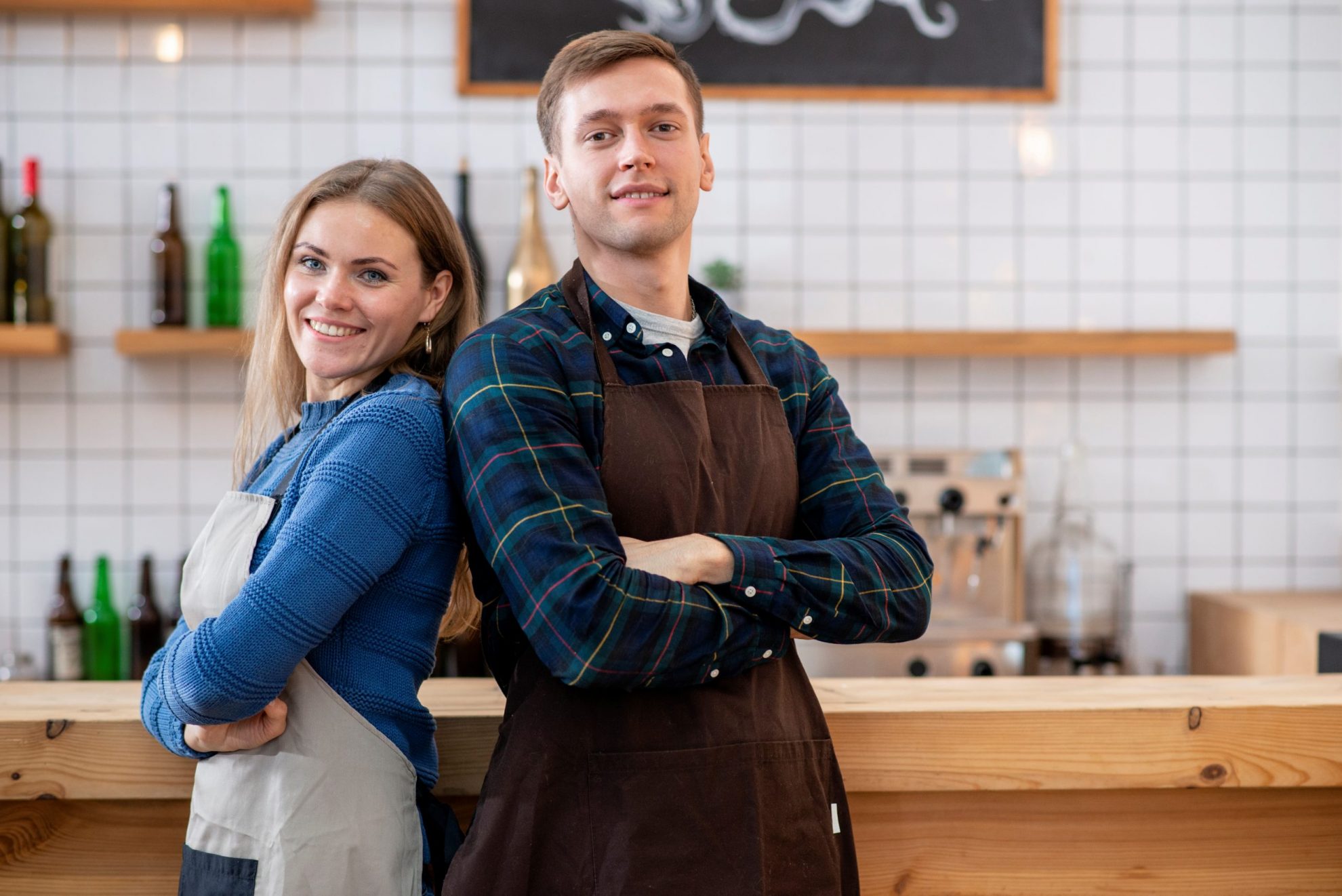 Man and woman wearing aprons illustrate blog "504 Loans for Restaurants: What You Need To Know"