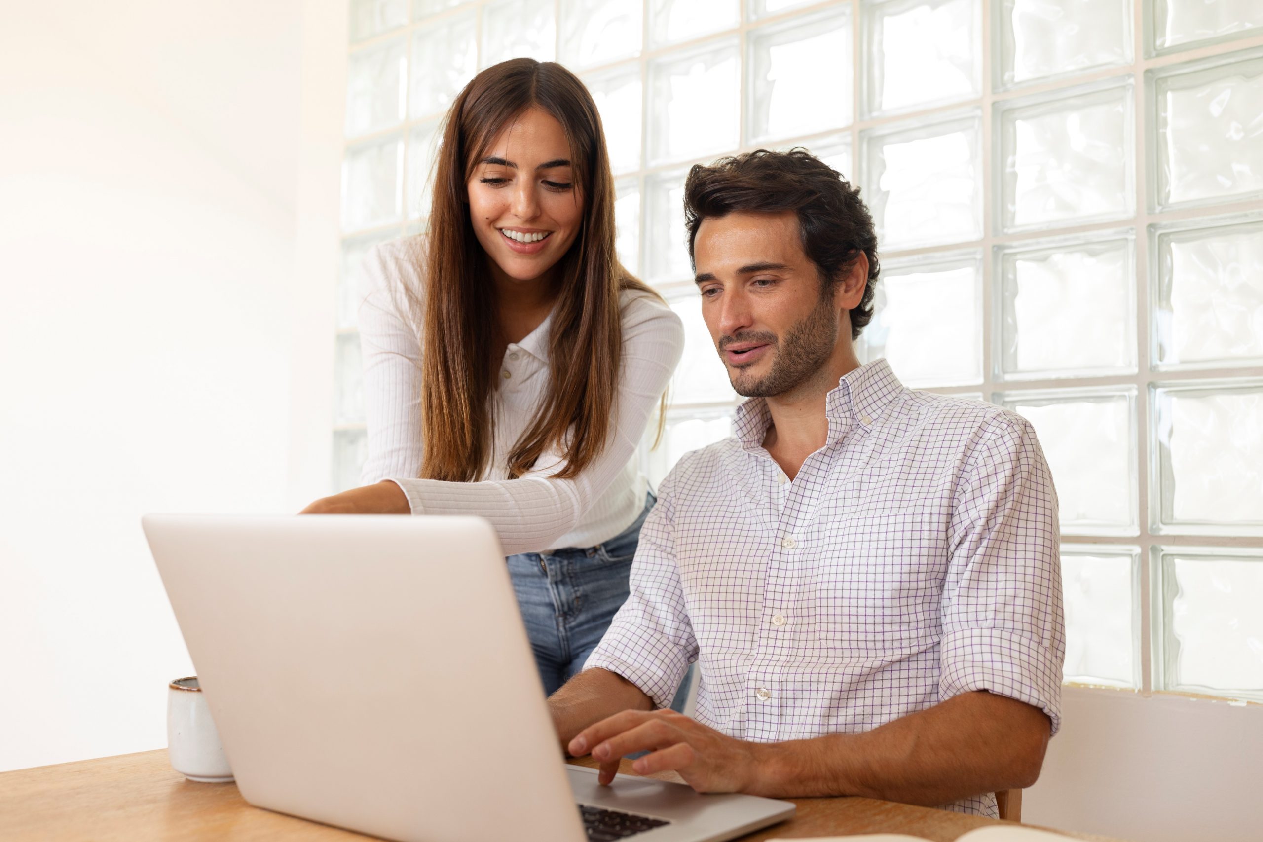 Woman and man looking at laptop illustrate blog "What Is Cost-Benefit Analysis?"