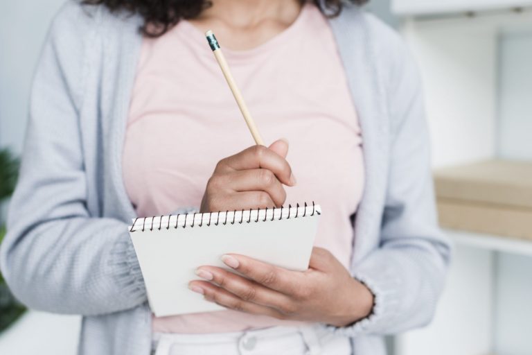Closeup of woman holding notepad illustrates blog "Do SBA Loans Have Interest?"